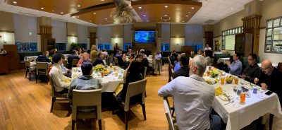 Panoramic photo of people at conference dinner